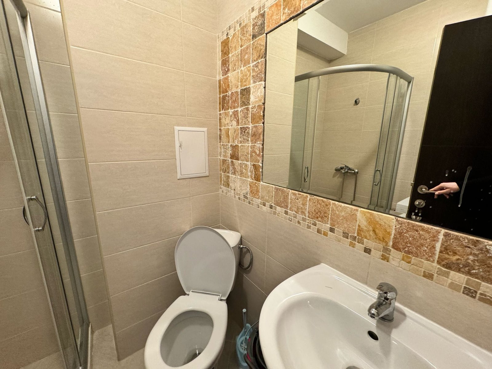 Современный санузел с душевой кабиной, унитазом и раковиной, оформленный в светлых тонах для продажи недвижимости в Болгарии.