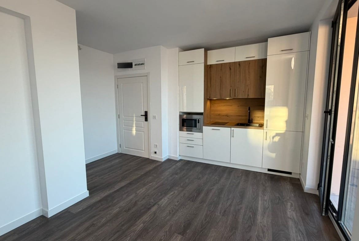 Современная кухня в квартире в Болгарии с деревянными элементами, светлым дизайном и открытой планировкой.