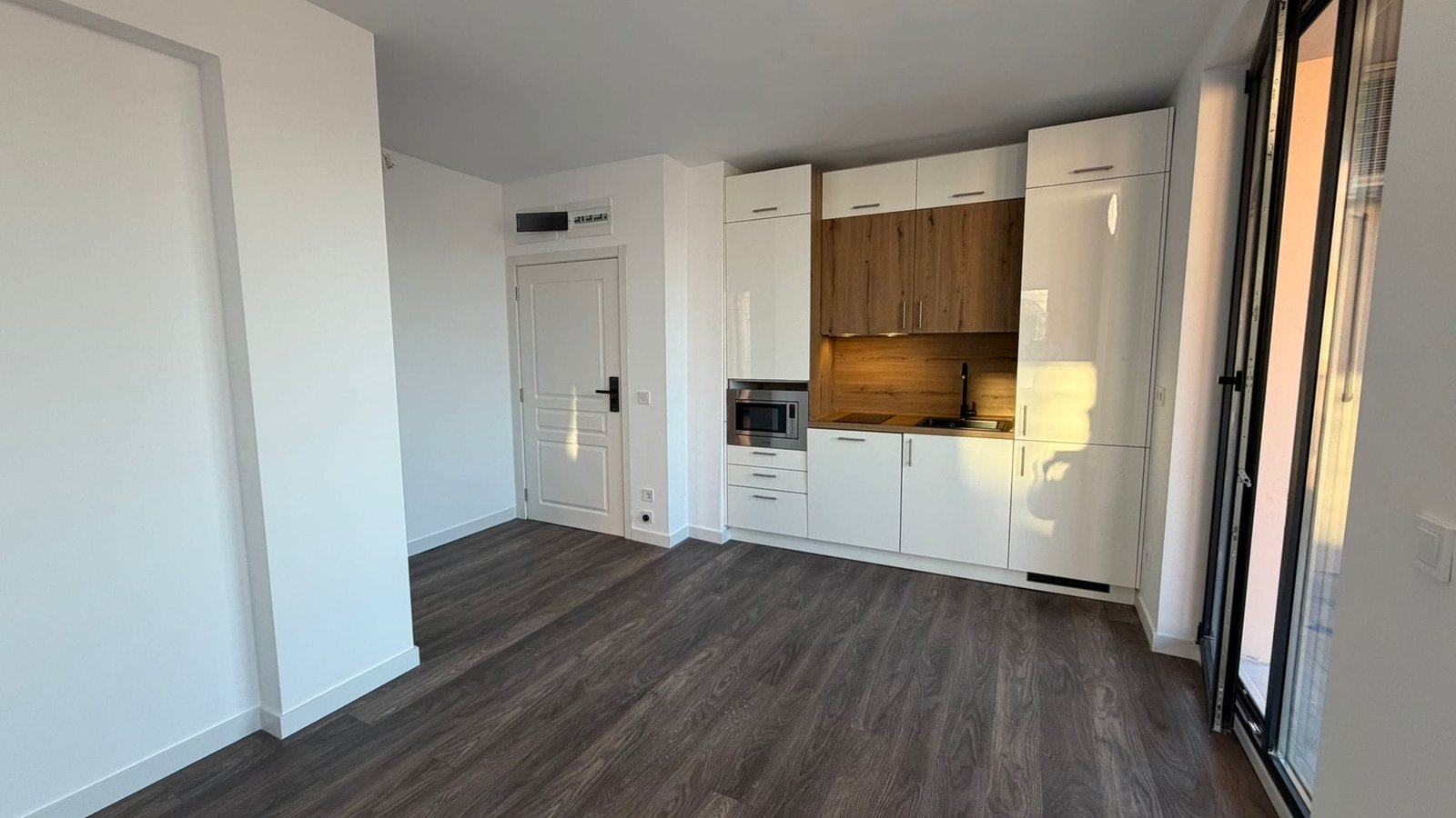 Кухня в стиле минимализм в современном интерьере квартиры Современная кухня в квартире в Болгарии с деревянными элементами, светлым дизайном и открытой планировкой.