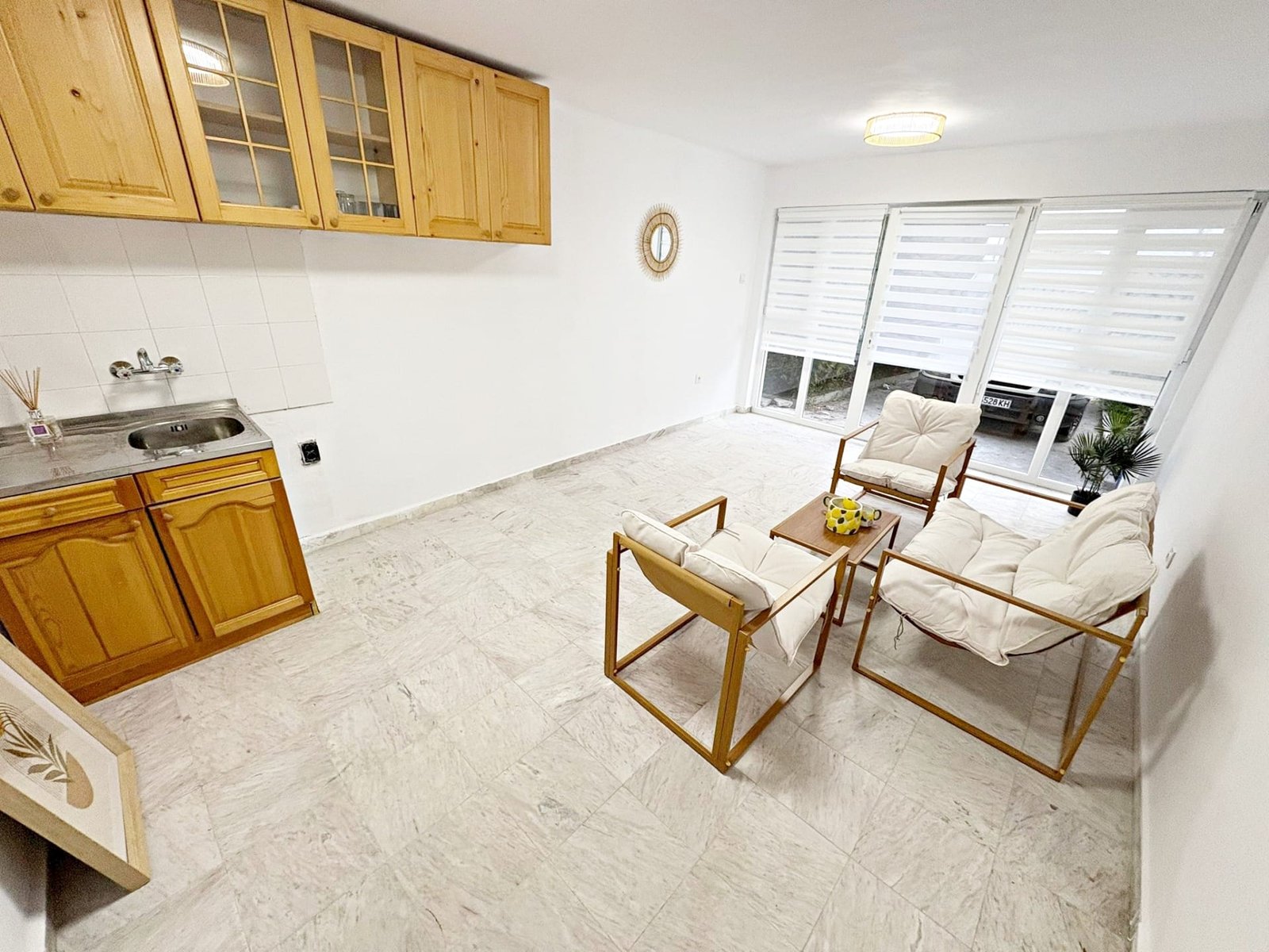 Светлая квартира с кухонным уголком, диваном и большими окнами, готовая для продажи в Болгарии.