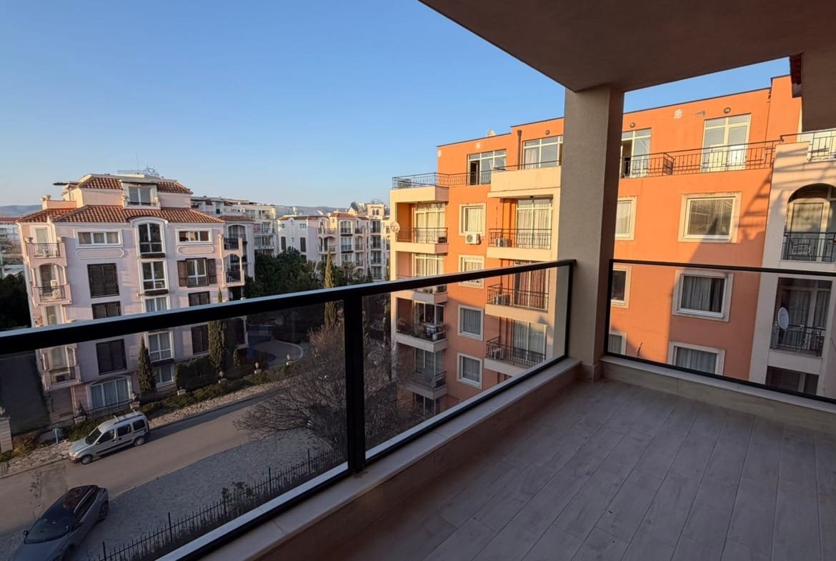 Балкон с видом на жилые здания в Болгарии, идеальное место для покупки недвижимости у моря. Светлые цвета и просторный дизайн.