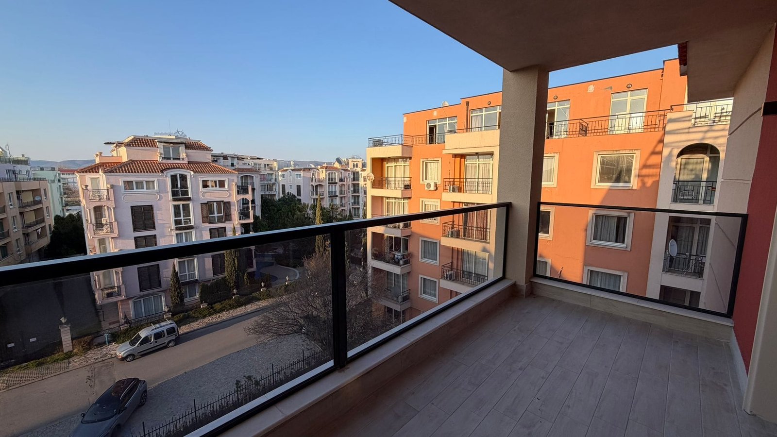 Балкон с видом на жилые дома в европейском городе Балкон с видом на жилые здания в Болгарии, идеальное место для покупки недвижимости у моря. Светлые цвета и просторный дизайн.