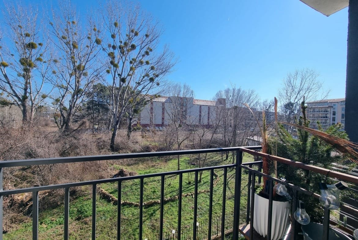 Вид с балкона на зелёный ландшафт и здания в Болгарии, идеальное место для покупки недвижимости у природы.