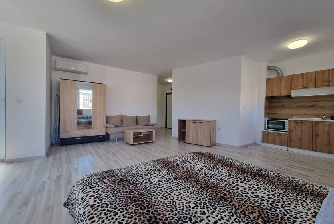 Современная квартира в Болгарии с деревянной мебелью, светлыми стенами и открытым пространством для комфортного проживания.