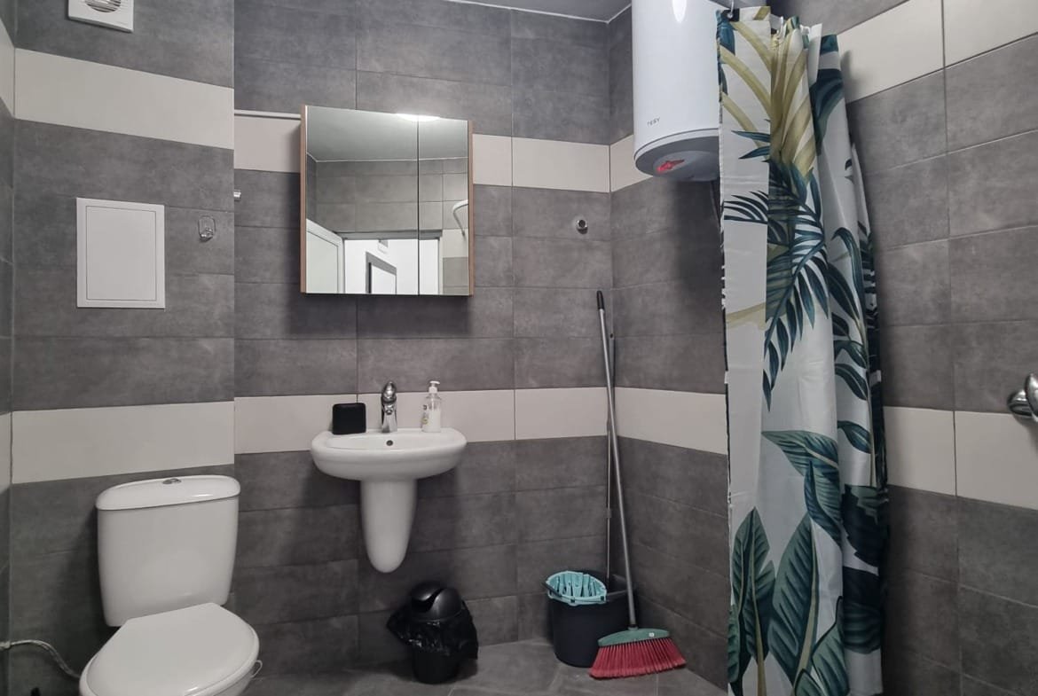 Современная ванная комната с душевой кабиной, унитазом, раковиной и стильной отделкой в нейтральных тонах.