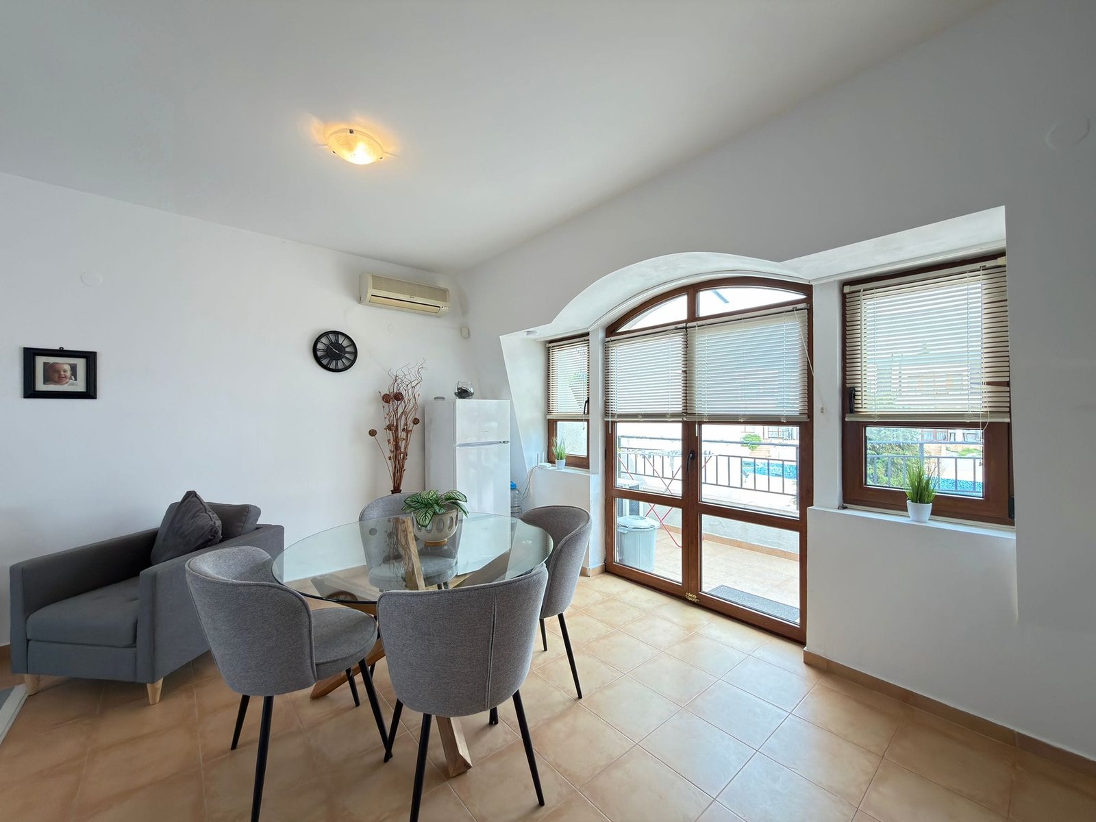 Современная квартира в Болгарии с обеденной зоной, большими окнами и видом на бассейн. Идеальное место для покупки недвижимости.