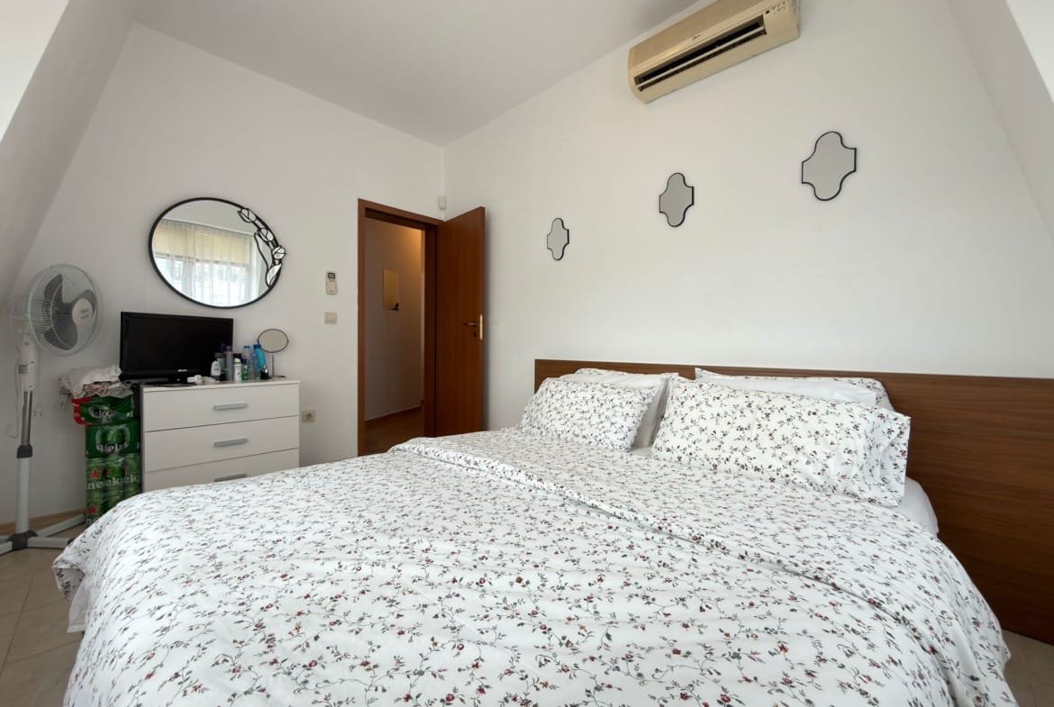 Современная спальня с двуспальной кроватью, белым текстилем и климат-контролем, подходящая для аренды в Болгарии.