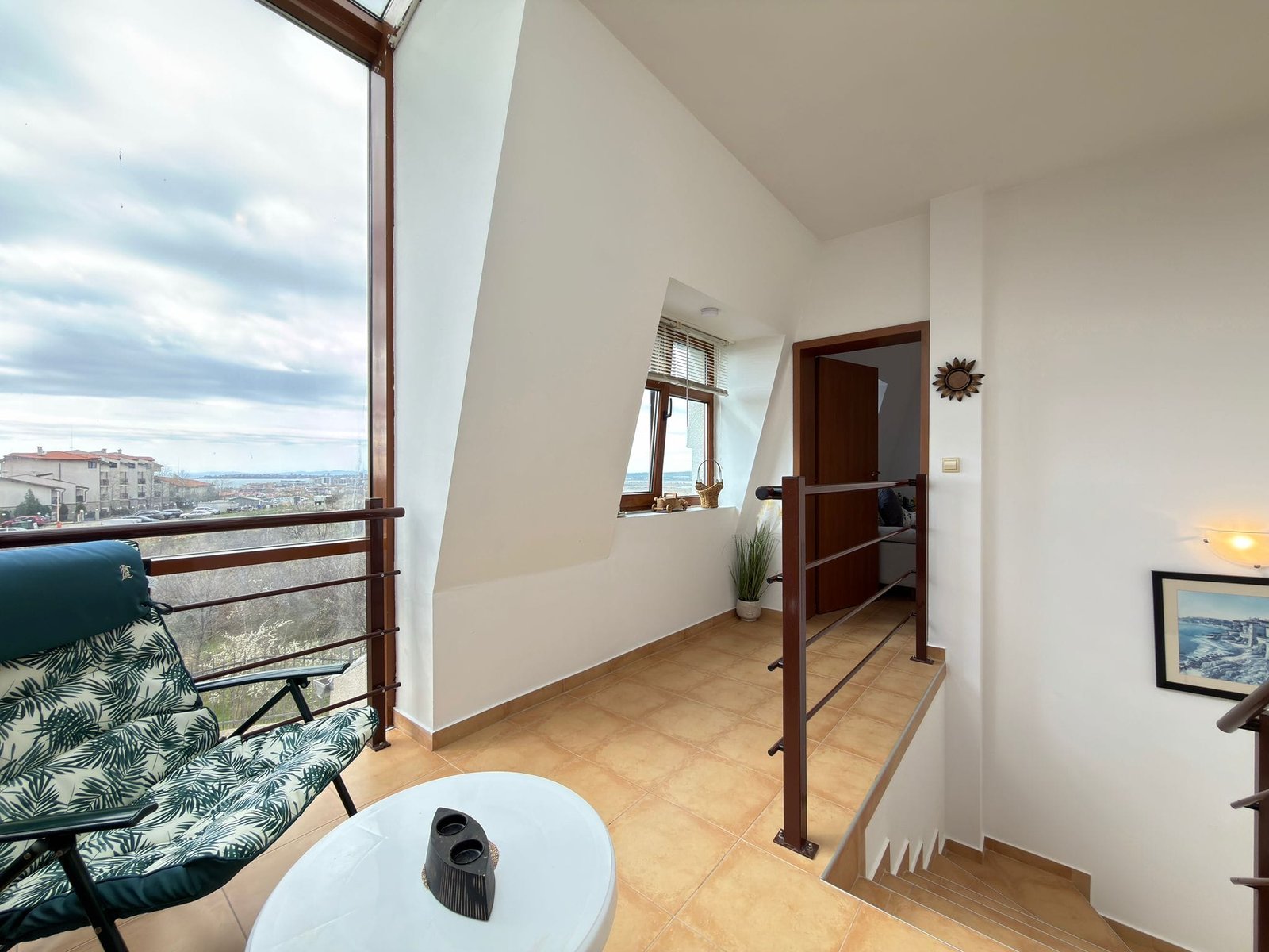 Уютная комната с красивым видом, светлыми стенами и современными элементами, идеальна для продажи недвижимости в Болгарии.