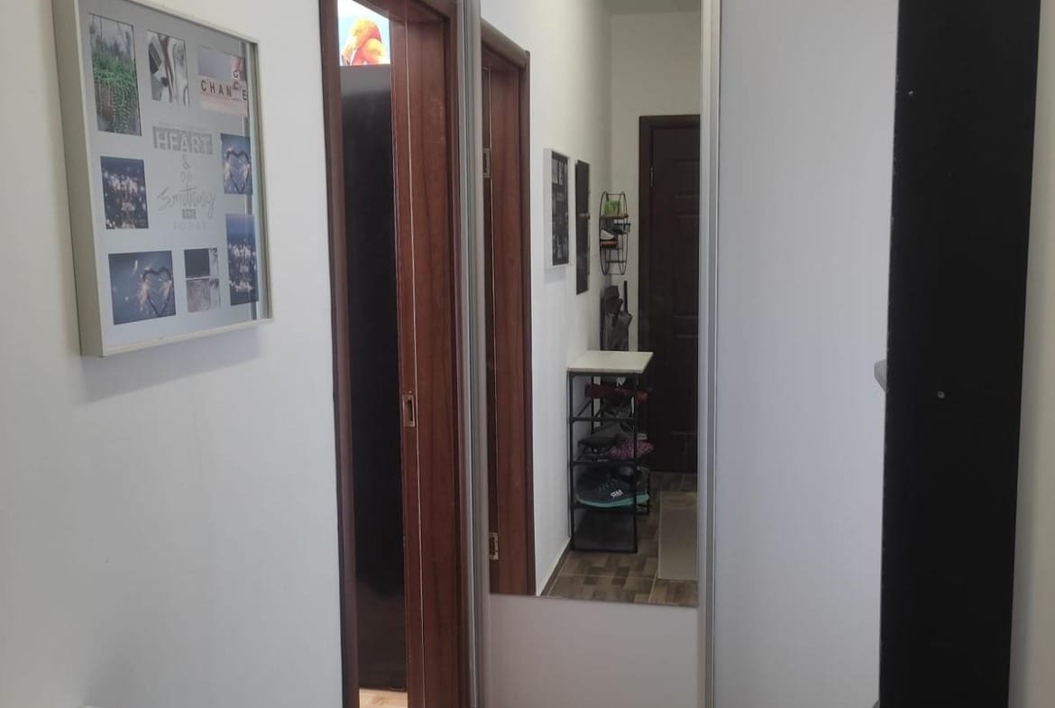 Современный коридор с зеркальным шкафом, светлыми стенами и деревянным полом, идеально подходит для покупки недвижимости в Болгарии.