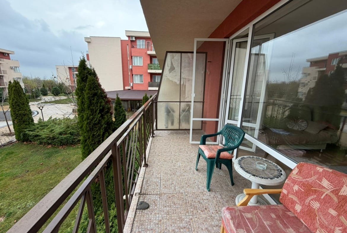 Современный балкон с креслом и растительностью, виды на жилые здания, идеальное место для жизни и отдыха в Болгарии.