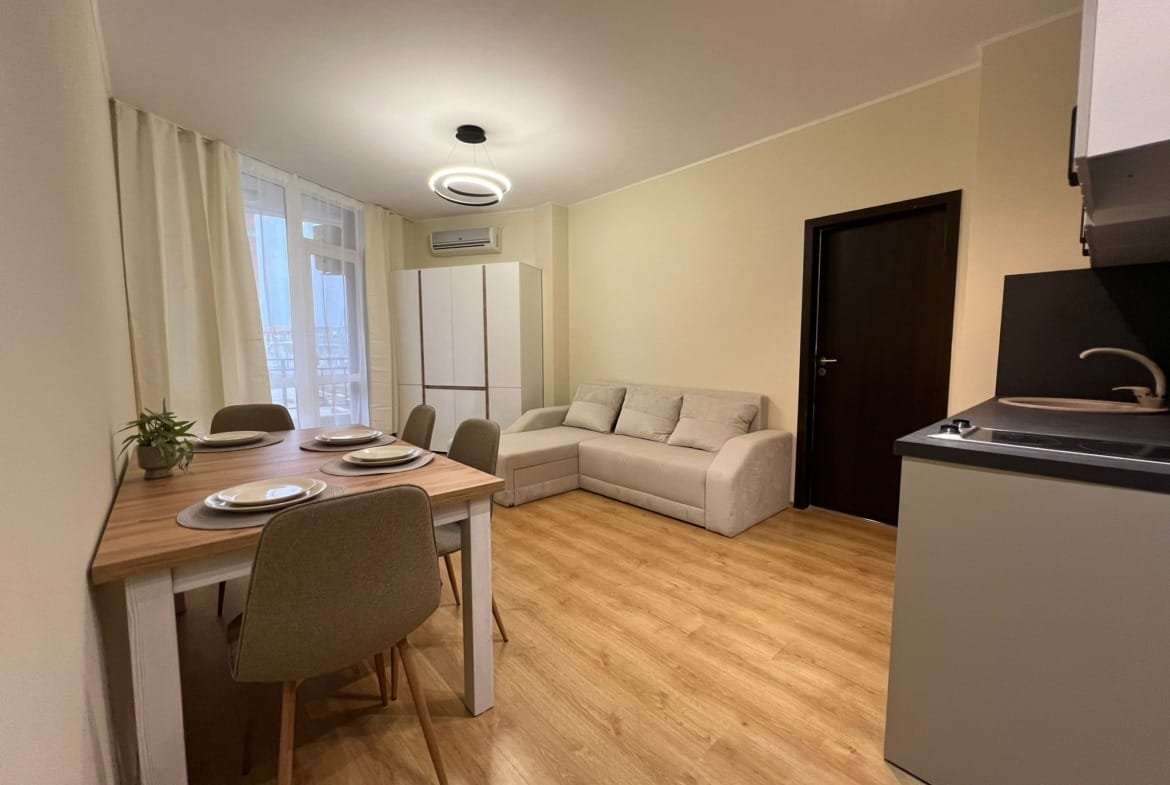 Современная квартира с кухней, обеденным столом и уютной зоной отдыха в Болгарии, готовая к продаже или аренде.