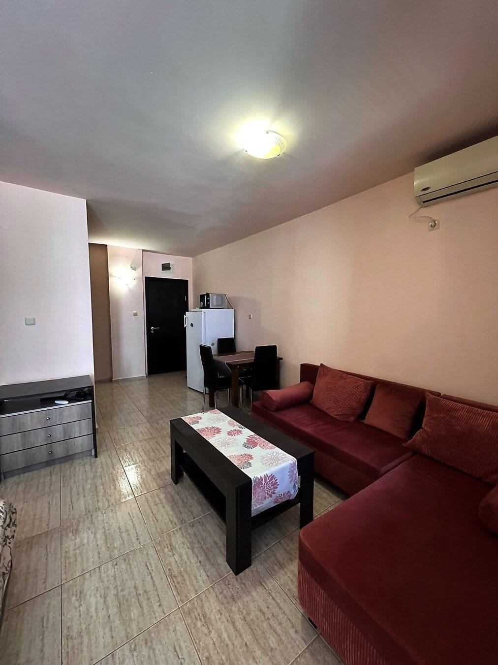 Современная квартира в Болгарии с уютным интерьером, диваном и обеденной зоной, идеальная для продажи или аренды.