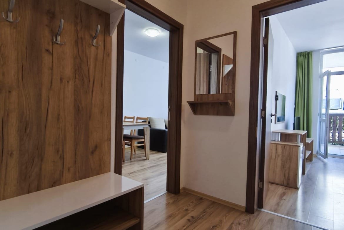 Современный интерьер квартиры в Болгарии с прихожей, обеденной зоной и выходом на балкон из комнаты.