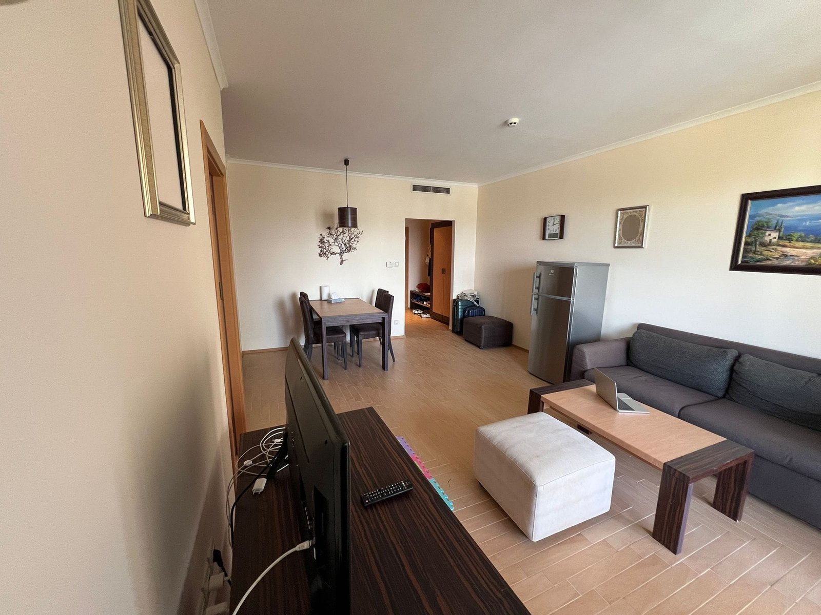 Современный интерьер гостиной с обеденной зоной и кухней Современный интерьер квартиры в Болгарии с мебелью, телевидением и обеденной зоной, идеальной для продажи или аренды.