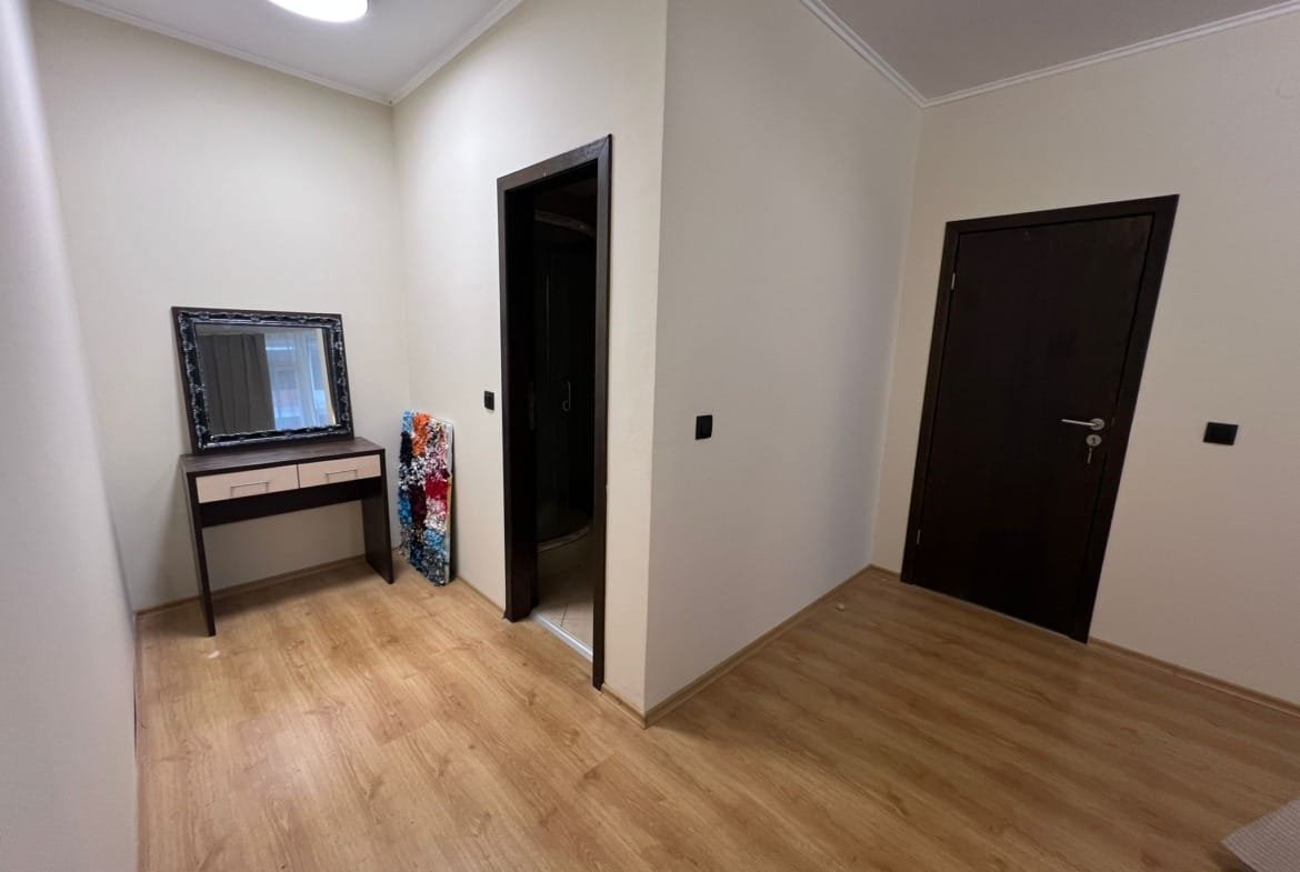 Современный коридор с зеркалом, комодом и дверью в ванную, отделанный в светлых тонах, подходит для продажи недвижимости в Болгарии.