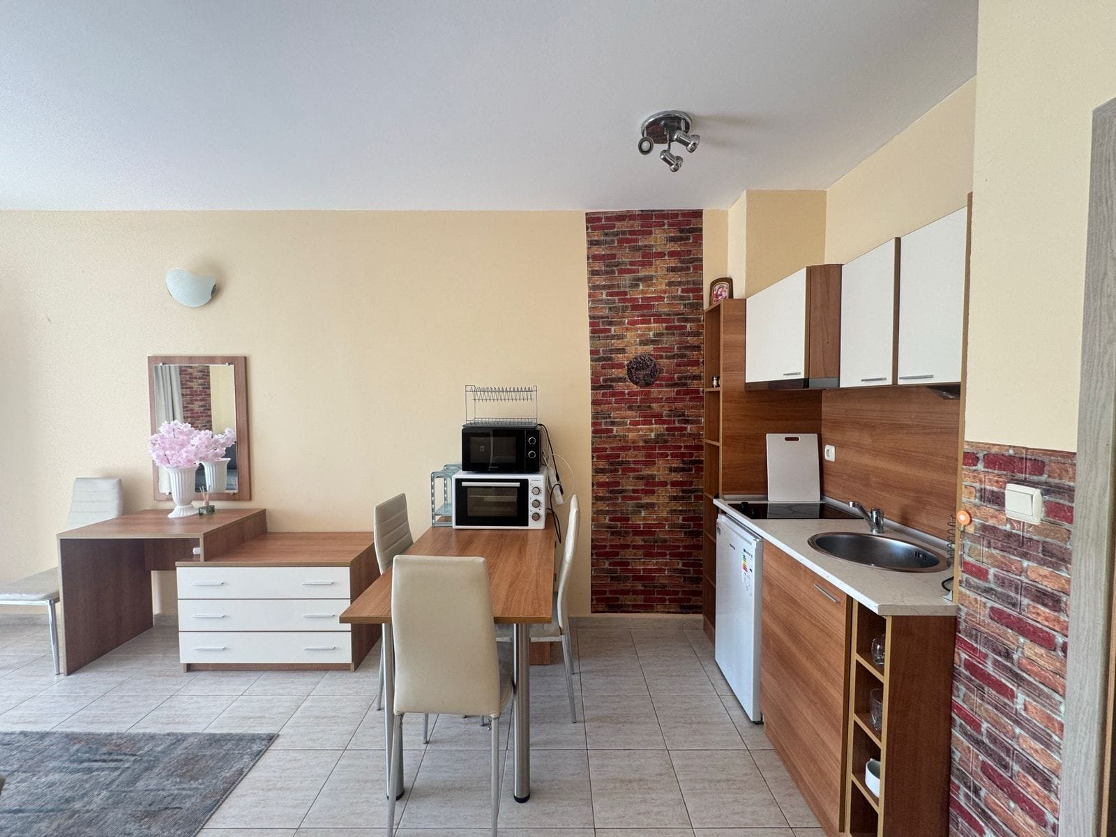 Современная кухня-гостиная с обеденным столом, бытовой техникой и уютным интерьером для комфортной жизни в Болгарии.