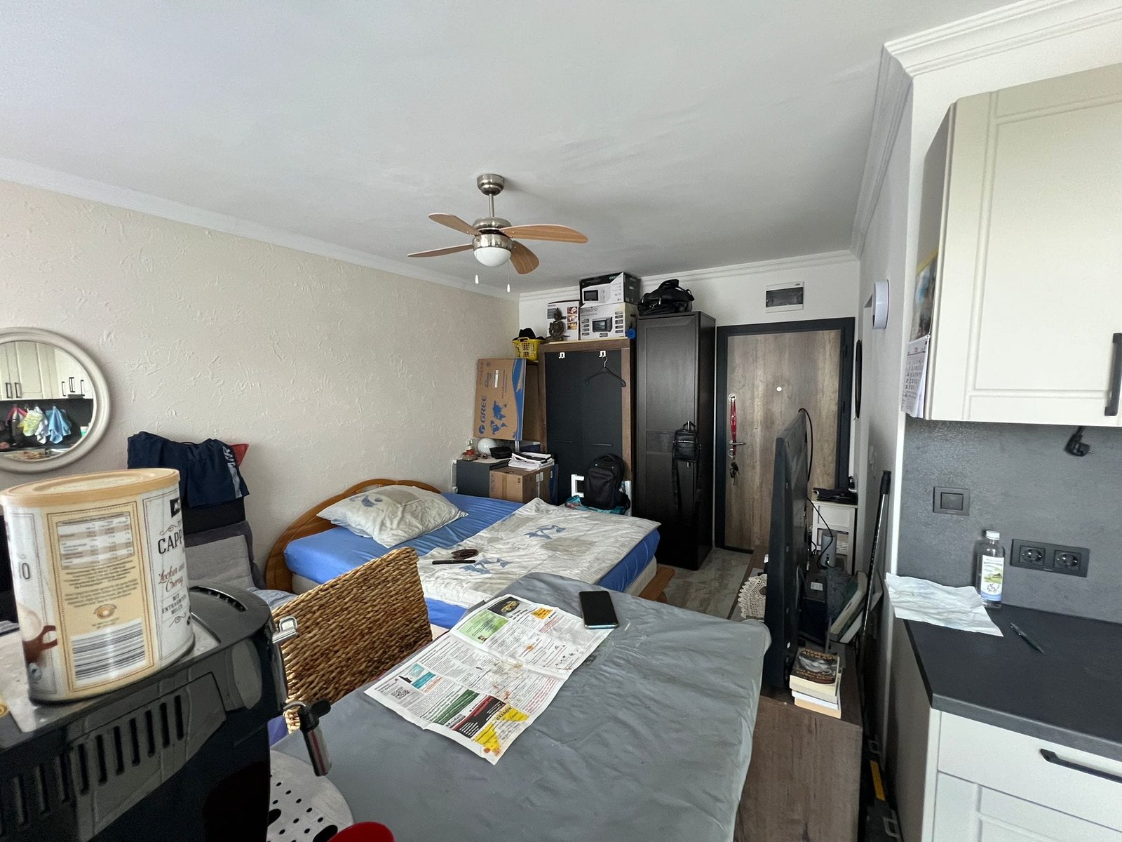 Уютная комната с двуспальной кроватью, кухонным уголком и мебелью, подходящая для продажи недвижимости в Болгарии.