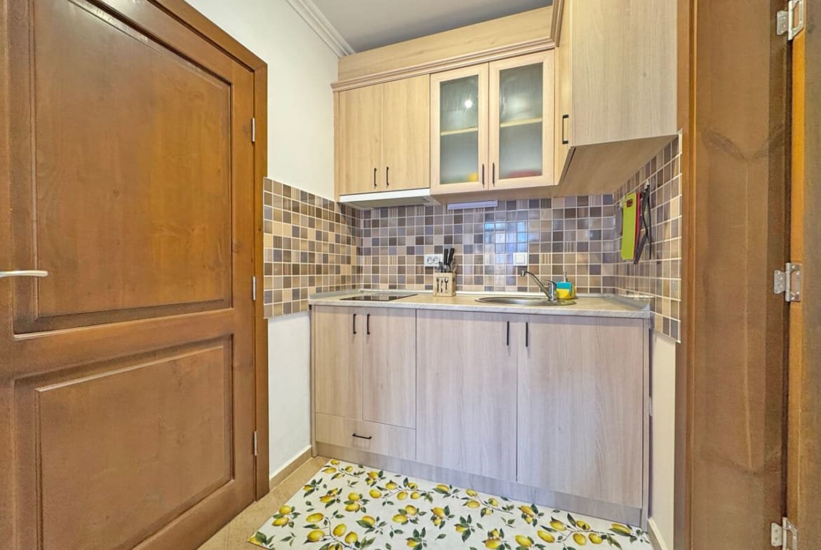 Кухня в квартире с современной мебелью и плиткой, светлые тона, уютная атмосфера.