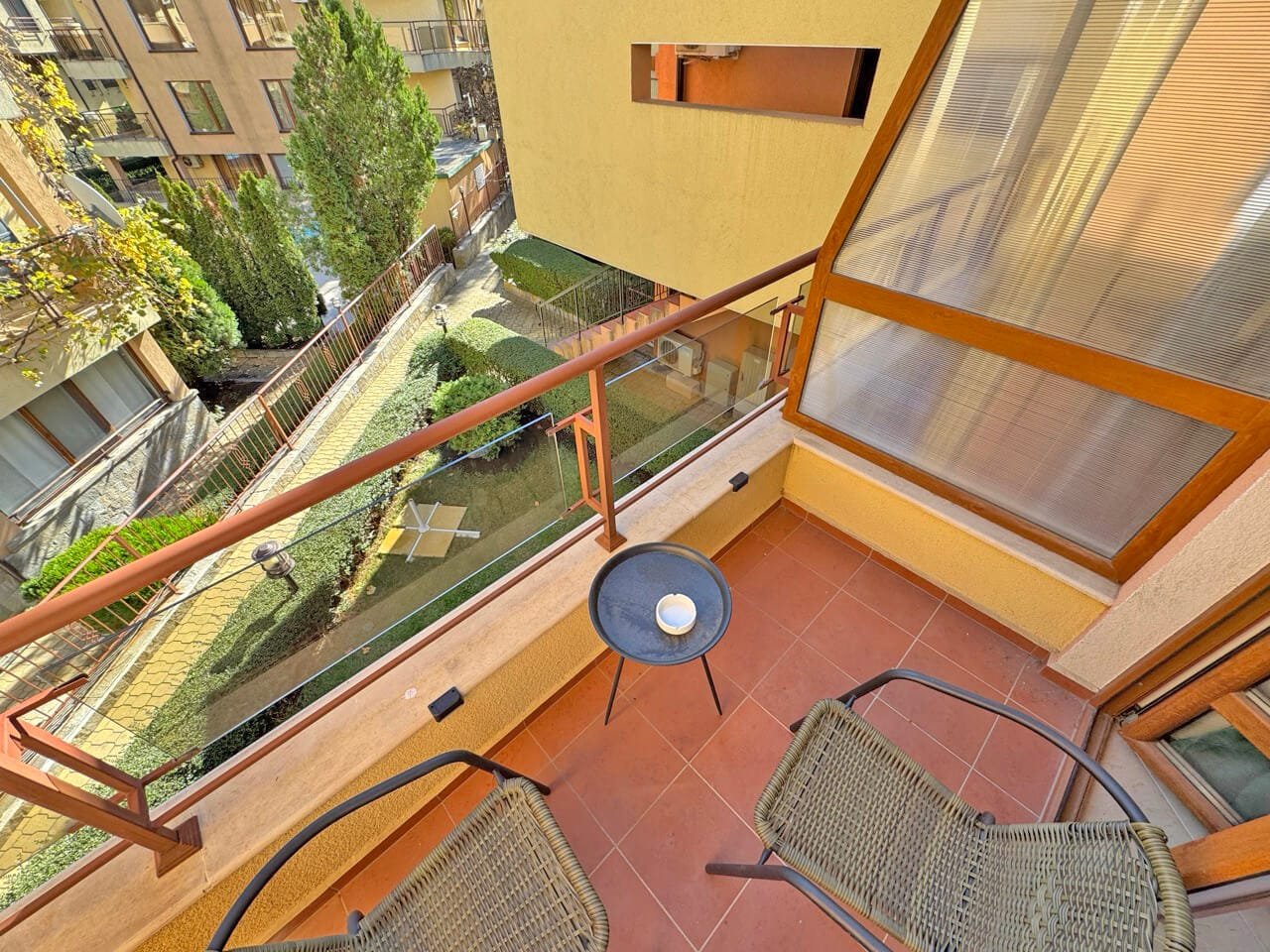 Терраса с креслами и видом на ухоженный сад, расположенная в квартире в Святом Власе, идеальная для отдыха у моря.