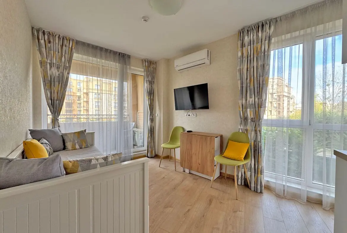 Современная гостиная с мягким уголком, телевизором и выходом на террасу, апартаменты у моря