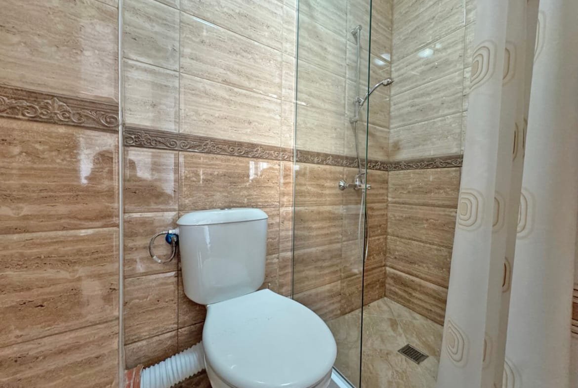 Современная ванная комната с душевой кабиной, отделка в светлых тонах, идеальна для апартаментов у моря в Болгарии.