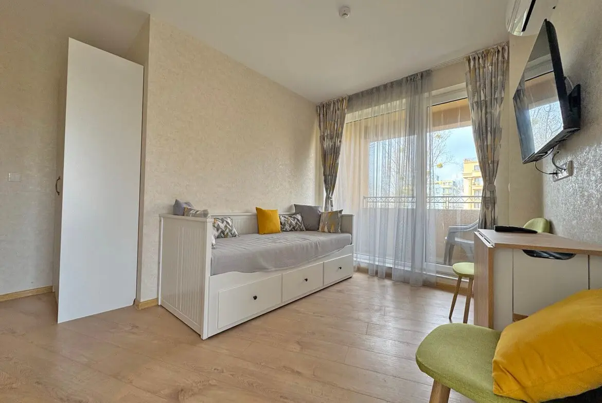 Современная гостиная с раскладным диваном, столиком и балконом, в квартире, идеальна для отдыха у моря.