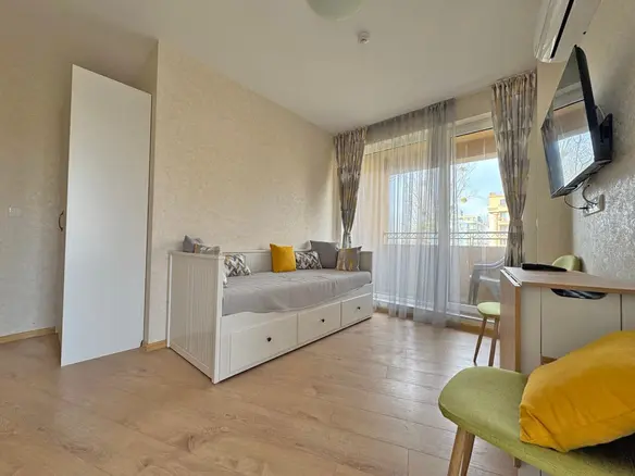 Современная гостиная с раскладным диваном, столиком и балконом, в квартире, идеальна для отдыха у моря.