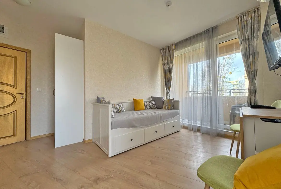 Современная квартира с уютной гостиной, балконом и светлым интерьером, идеально подходит для отдыха у моря.