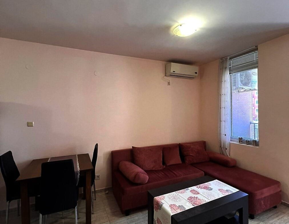 Современный интерьер квартиры в Болгарии с диваном, столом и стульями, идеален для комфортного проживания и аренды.