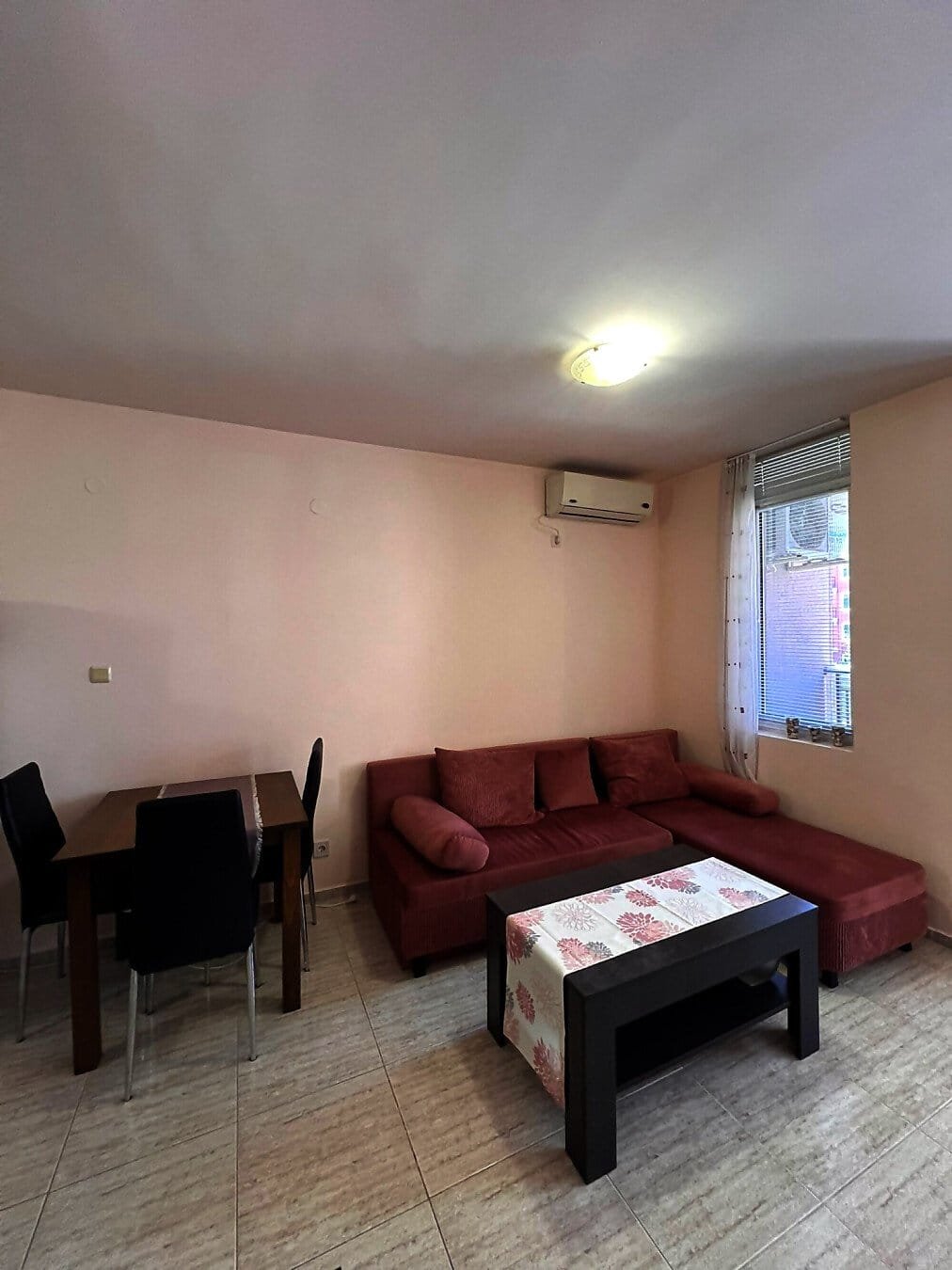 Современный интерьер квартиры в Болгарии с диваном, столом и стульями, идеален для комфортного проживания и аренды.