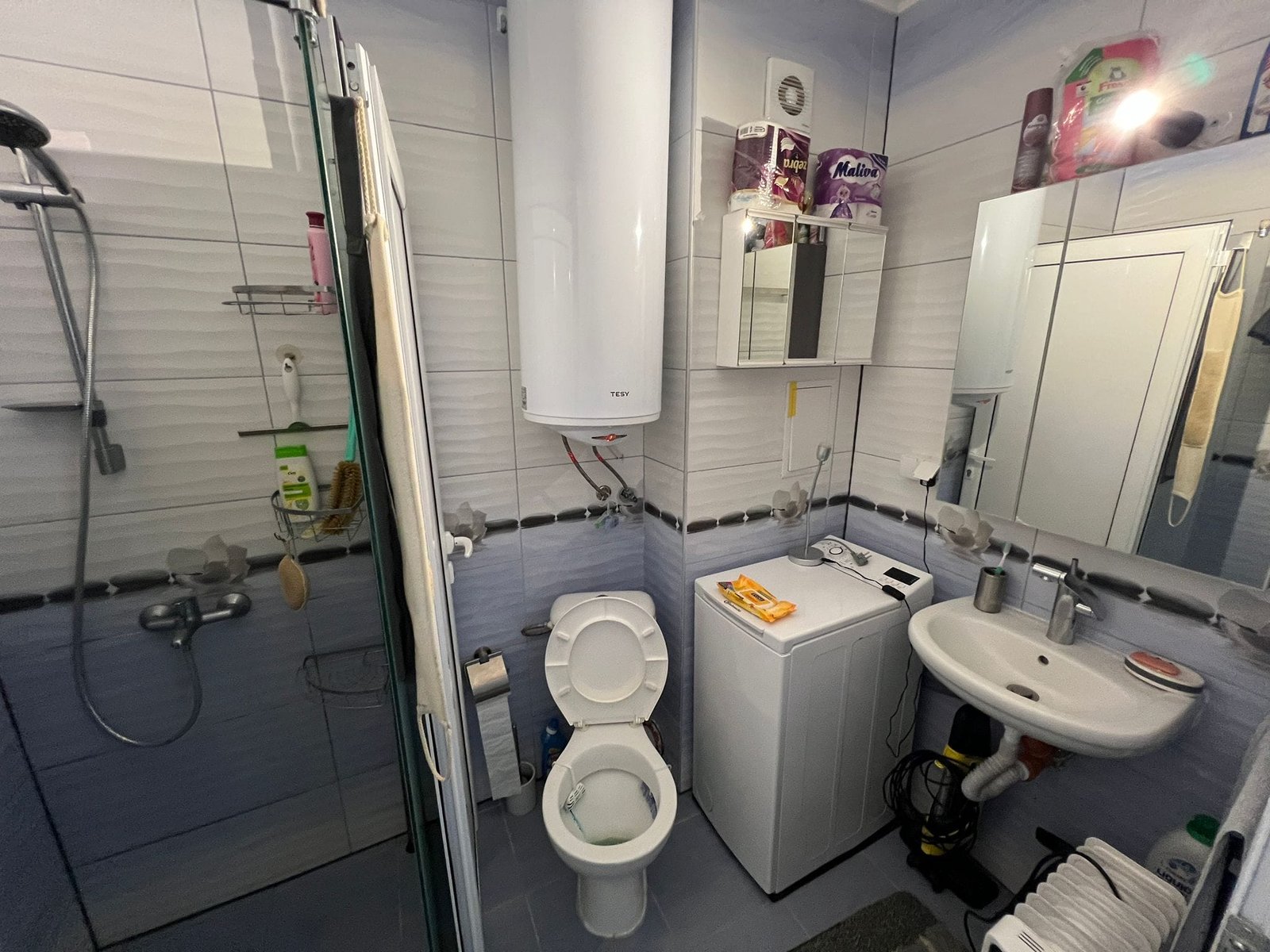 Современная ванная комната с душевой, унитазом, стиральной машинкой и зеркалом. Идеально для комфортной жизни в Болгарии.