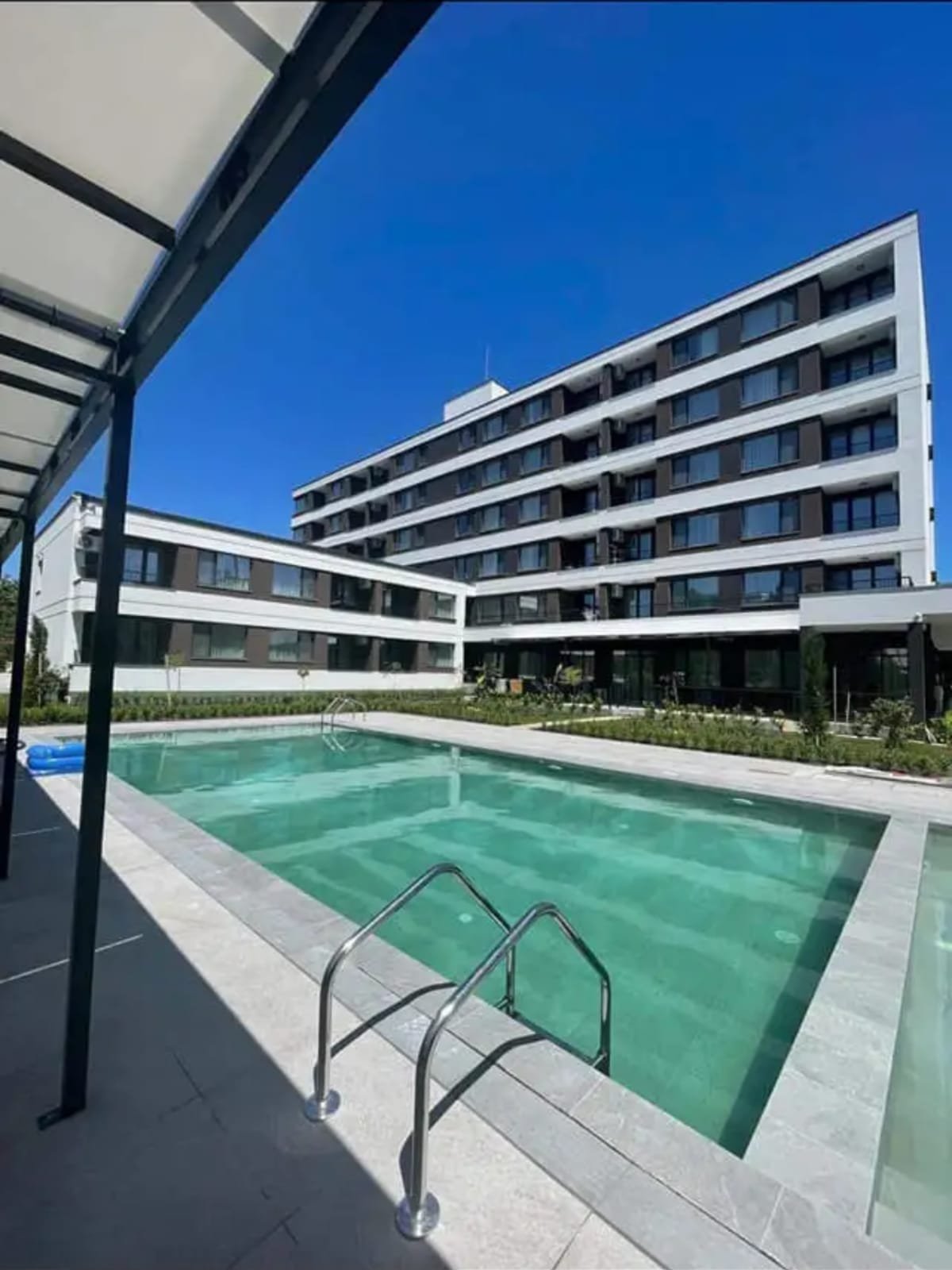 Современный жилой комплекс с бассейном и зелеными насаждениями в Болгарии, идеальное место для покупки недвижимости.