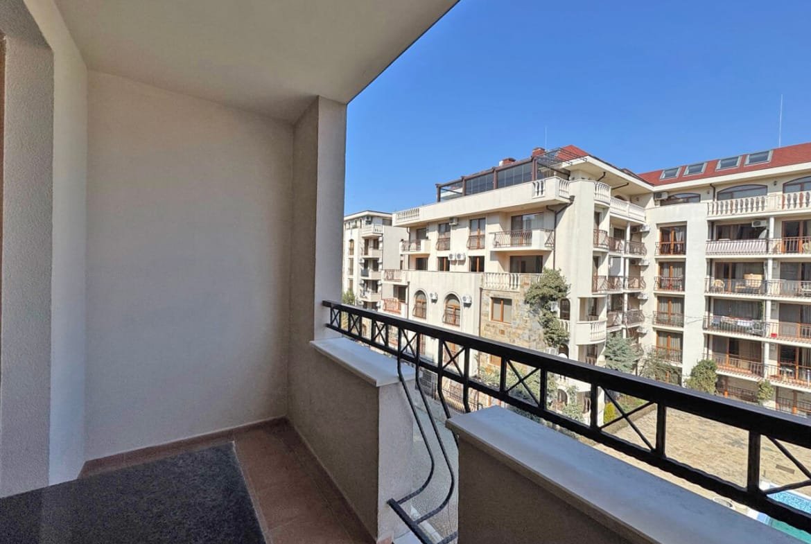 Балкон с видом на жилой комплекс, расположенный в Болгарии, ясное небо, уютное место для отдыха у моря.