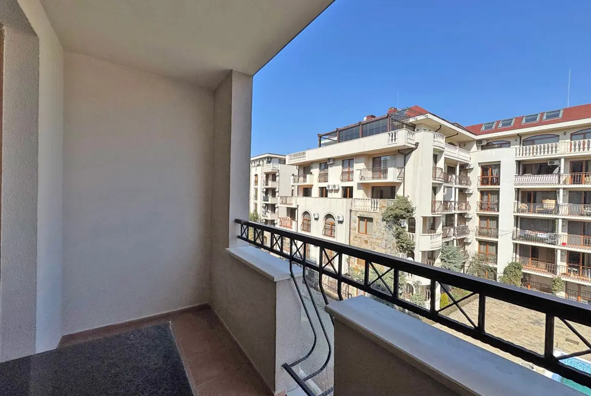 Балкон с видом на жилой комплекс, расположенный в Болгарии, ясное небо, уютное место для отдыха у моря.