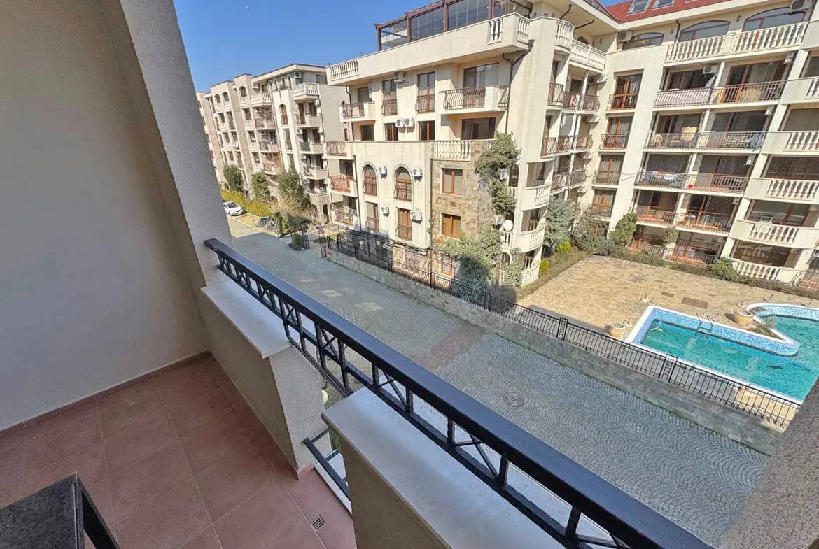 Балкон с видом на бассейн и жилые комплексы, расположенные в районе, идеально подходящий для покупки апартаментов у моря.