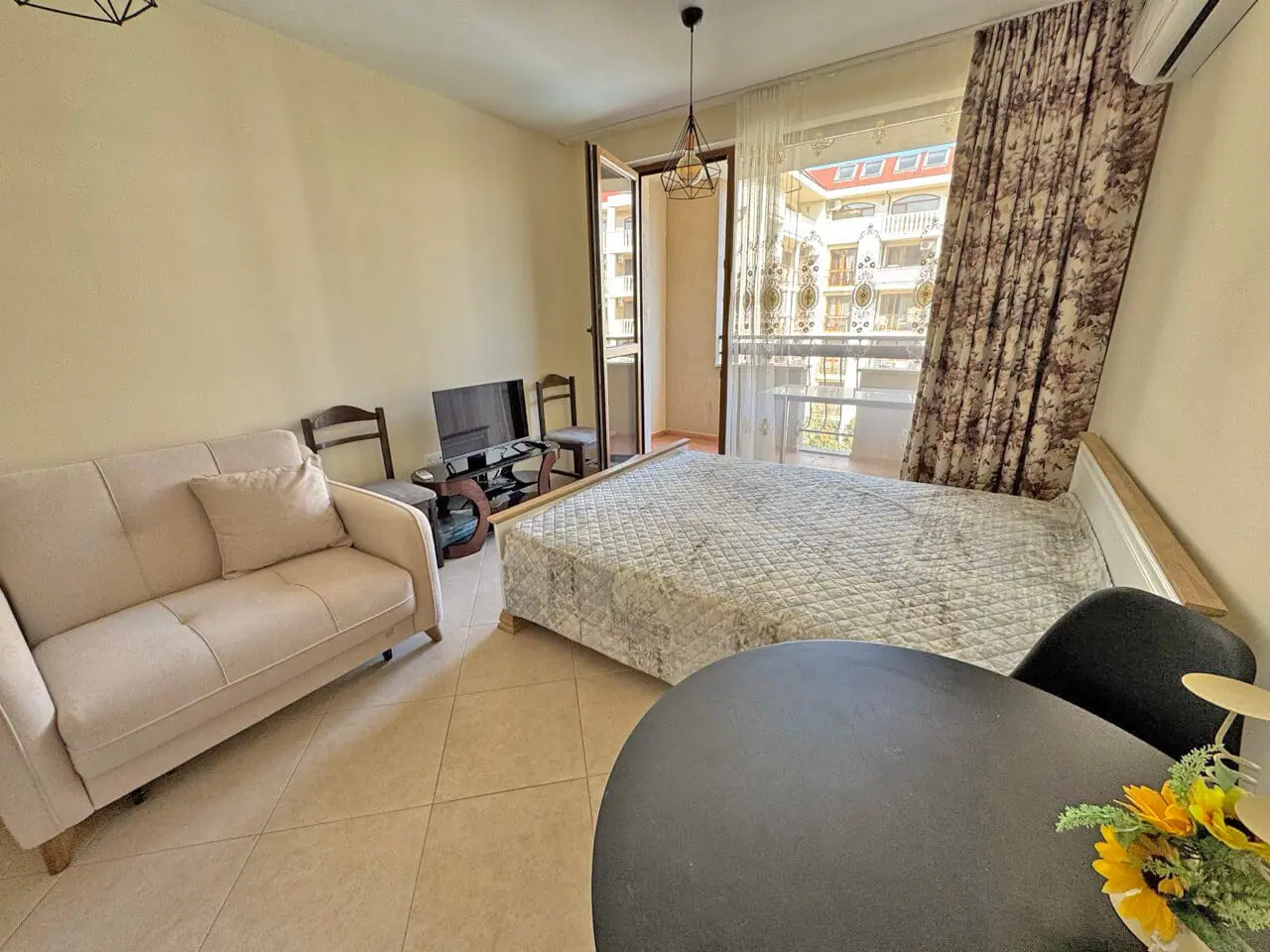 Современная квартира с мебелью, светлая гостиная, выход на балкон, уютная обстановка для отдыха у моря.