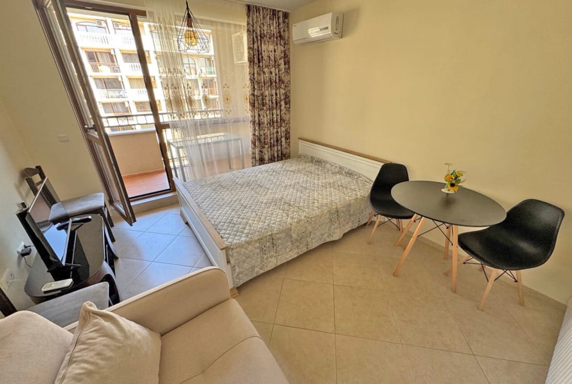 Современная квартира-студия с балконом, стильной мебелью и кондиционером, идеальна для отдыха у моря.