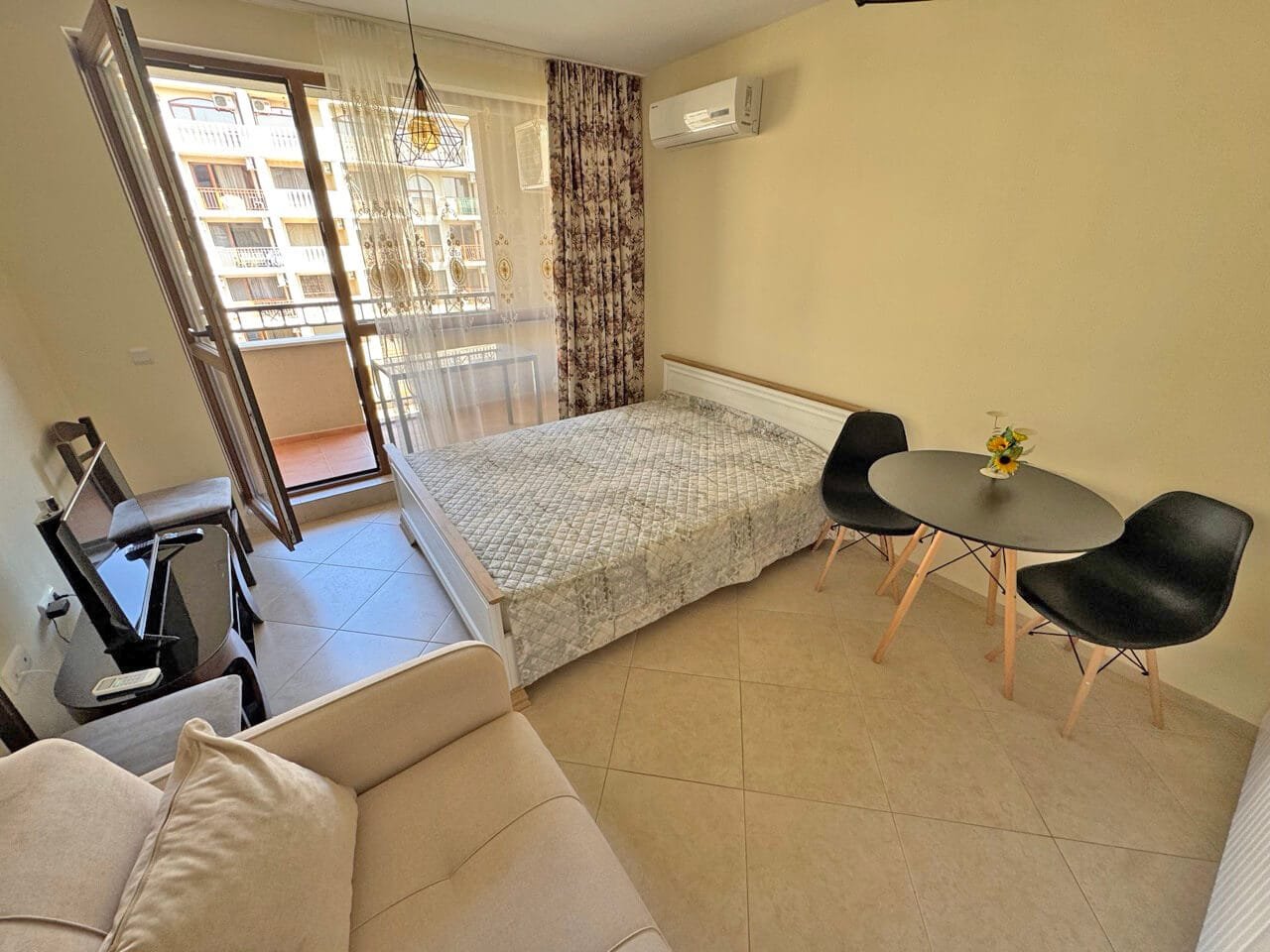 Современная квартира-студия с балконом, стильной мебелью и кондиционером, идеальна для отдыха у моря.