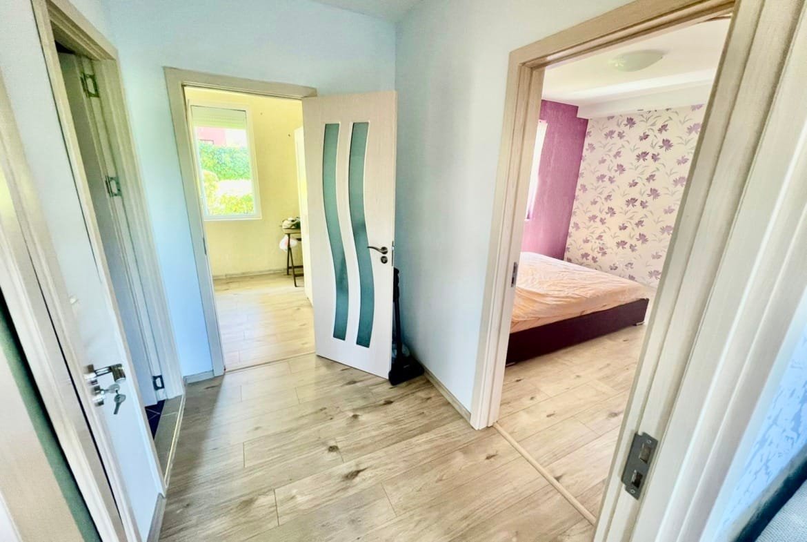 Современный интерьер квартиры в Болгарии с открытыми дверями и светлыми стенами, уютная спальня и яркие акценты.