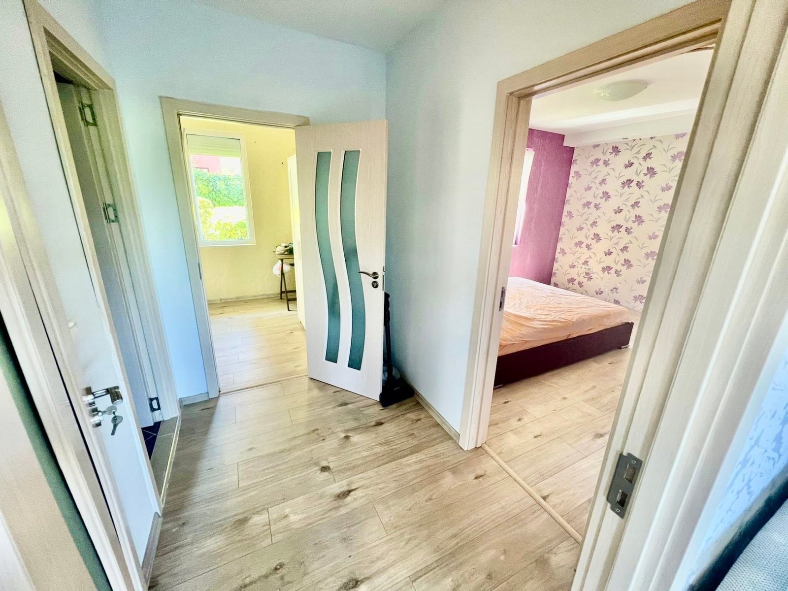 Современный интерьер квартиры в Болгарии с открытыми дверями и светлыми стенами, уютная спальня и яркие акценты.