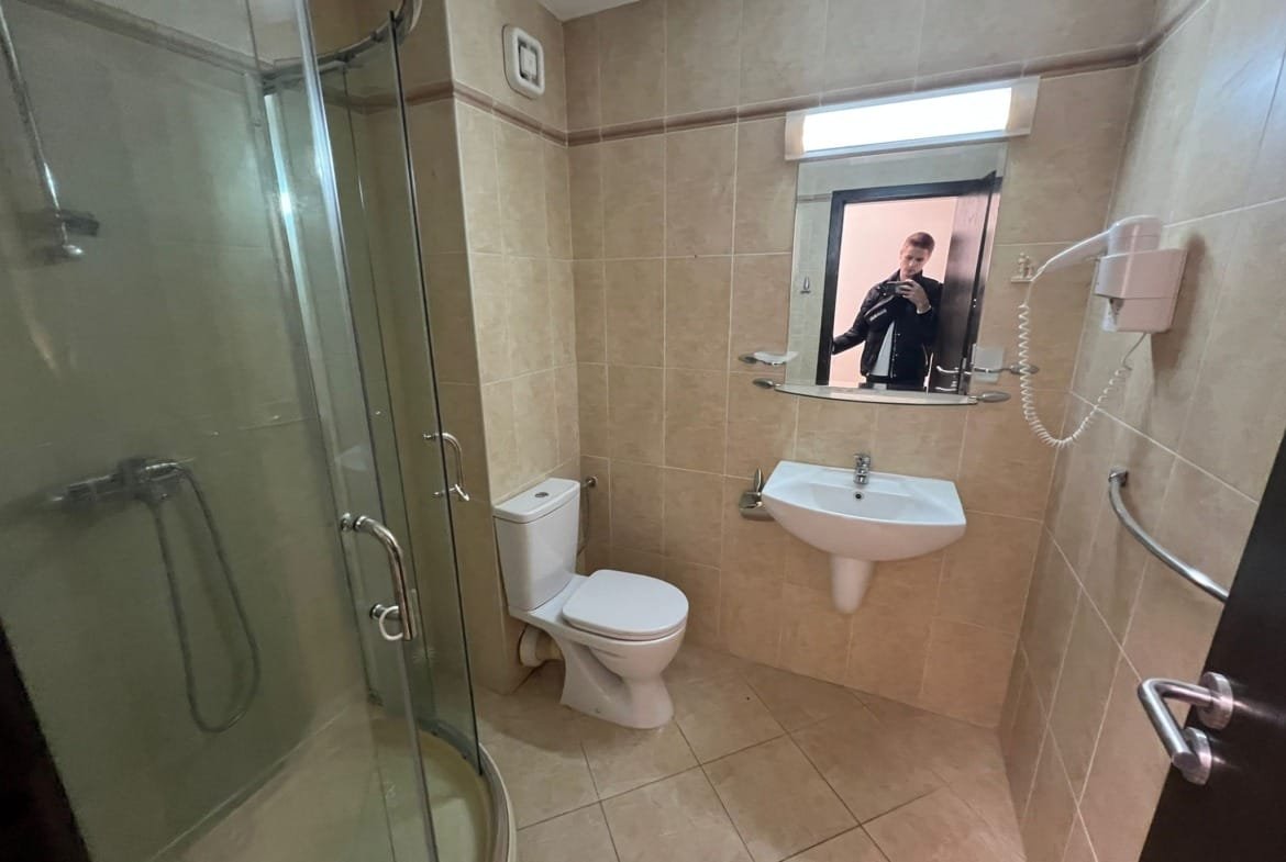 Современная ванная комната с душевой кабиной, унитазом и раковиной, оформленная в светлых тонах для стильной недвижимости в Болгарии.