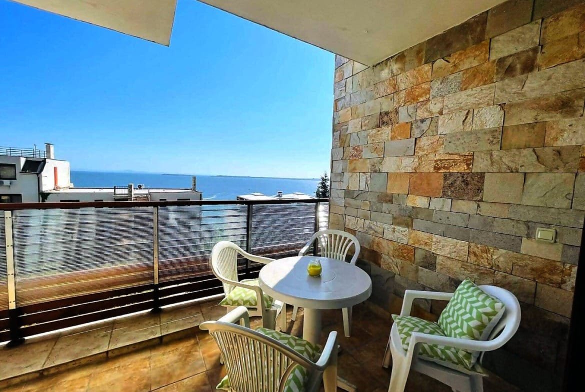 Балкон с видом на море, стол и стулья, идеально подходит для уютного отдыха в Болгарии у моря.