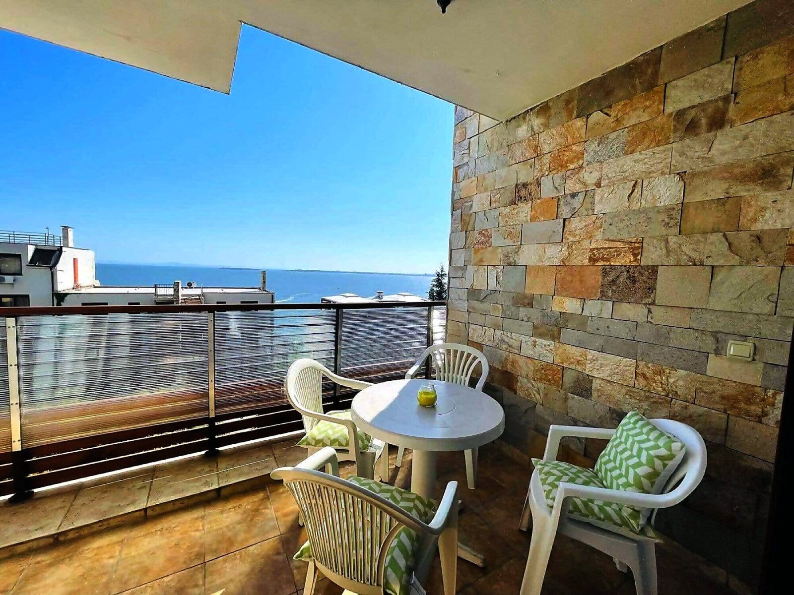 Балкон с видом на море, стол и стулья, идеально подходит для уютного отдыха в Болгарии у моря.