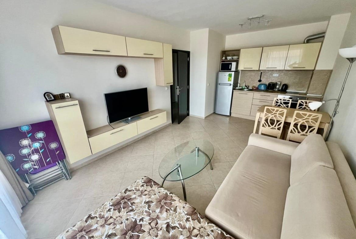 Современная квартира в Болгарии с гостиной, кухней и приятным интерьером, подходящая для аренды или покупки недвижимости.