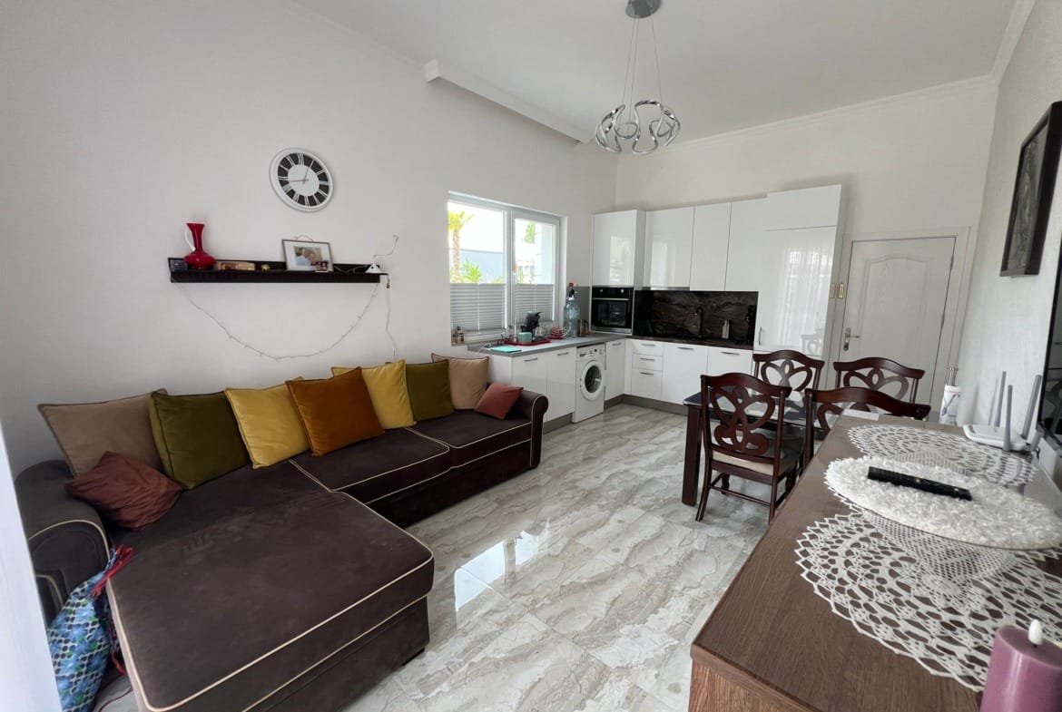 Уютная квартира с кухней-гостиной, современная мебель, светлые тона, идеальна для жизни или инвестиций в Болгарии.