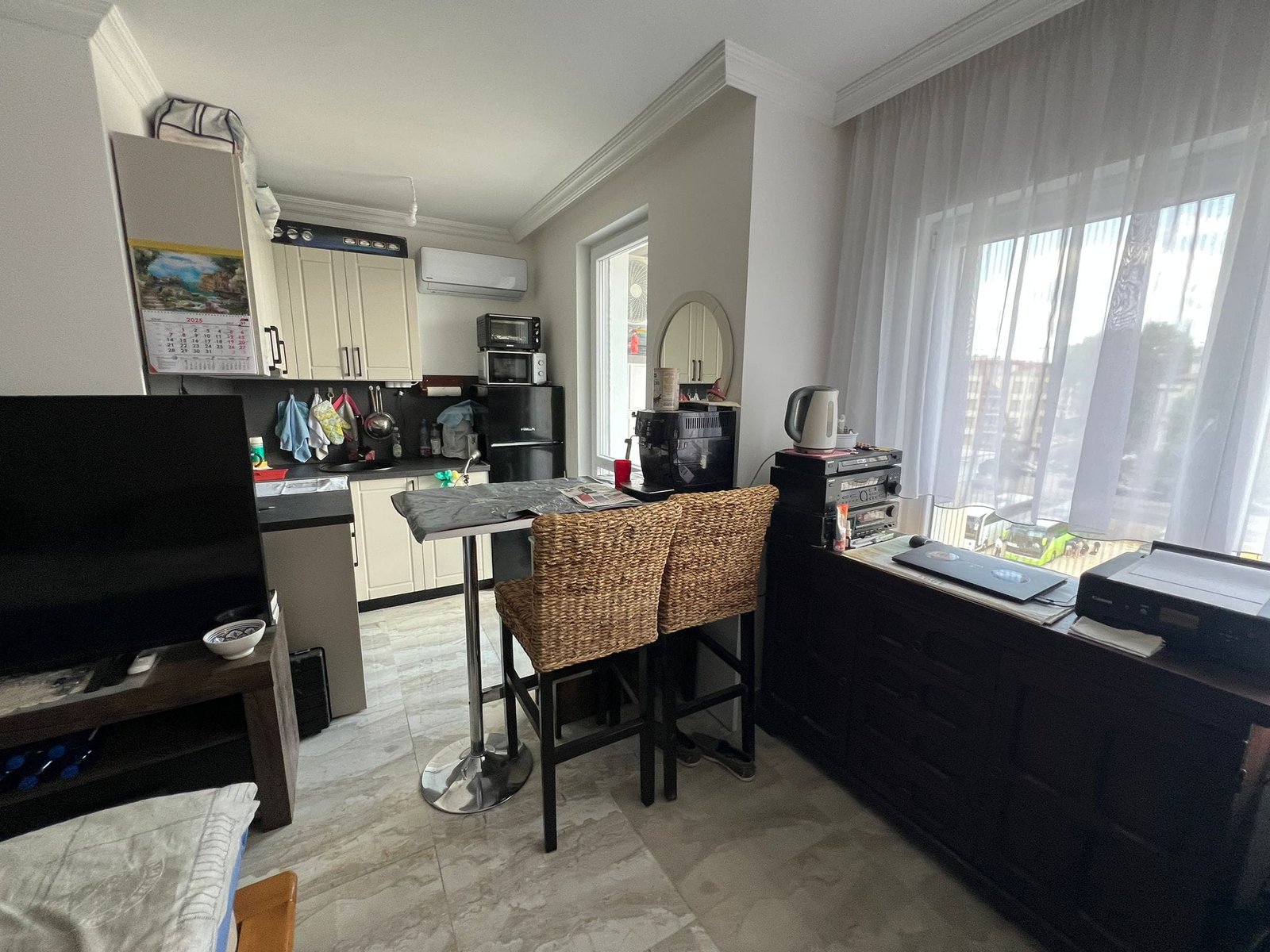 Современная кухня-студия в Болгарии с барной стойкой, бытовой техникой и обилием естественного света.