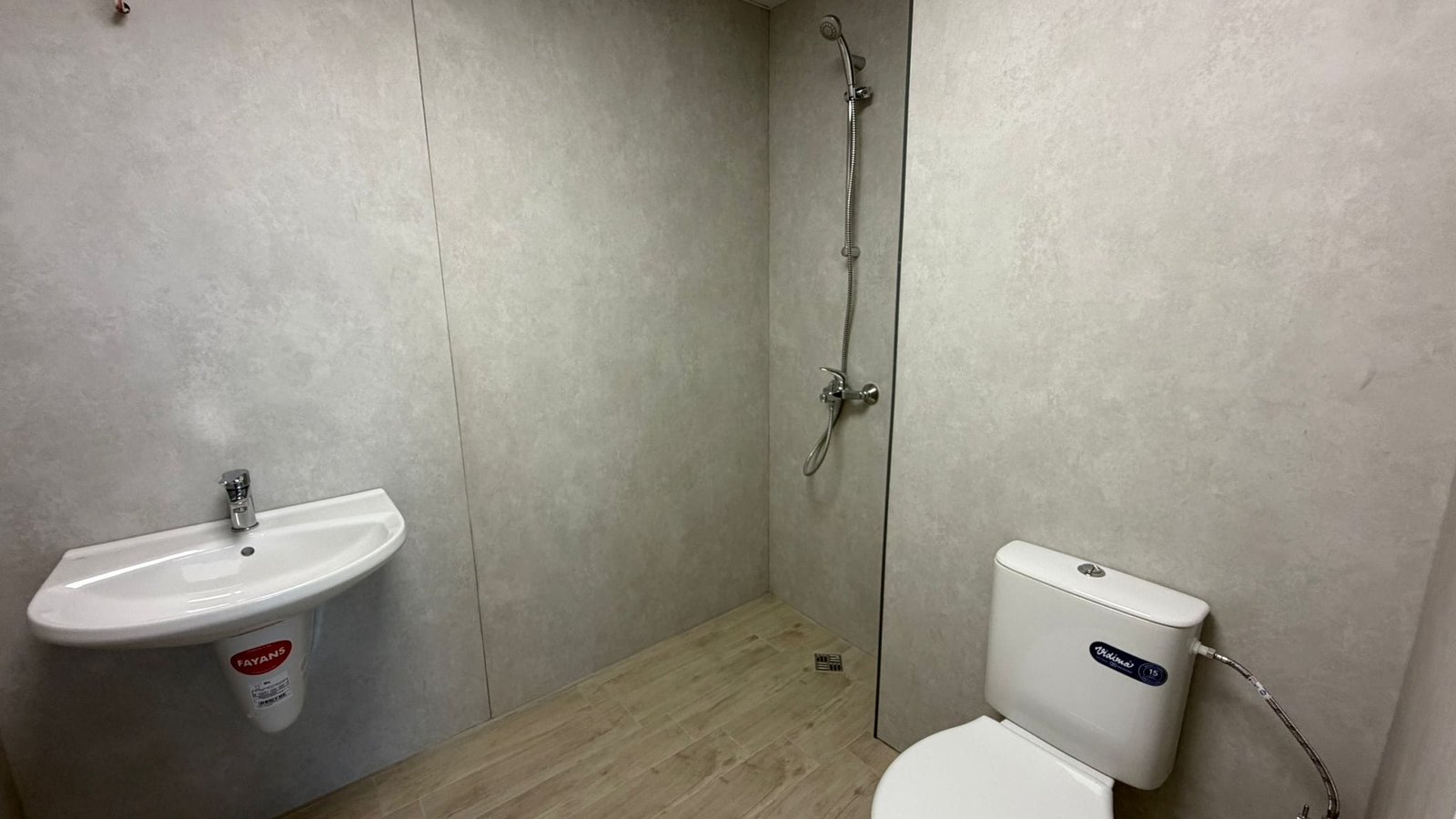 Современный санузел с душем и унитазом в нейтральных тонах Современная ванная комната с душевой кабиной, унитазом и раковиной, оформленная в нейтральных тонах для продажи недвижимости в Болгарии.