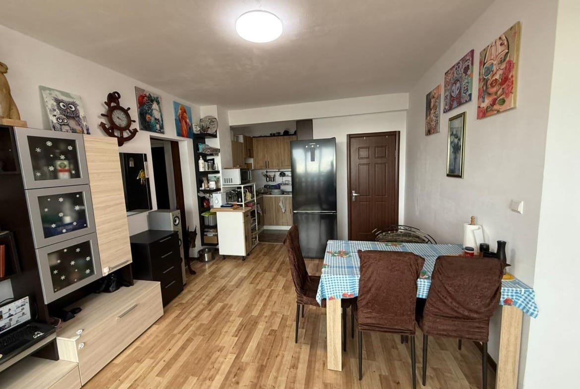 Современный интерьер квартиры с кухней и столовой, мебелью и художественными картинами, популярный вариант для покупки в Болгарии.