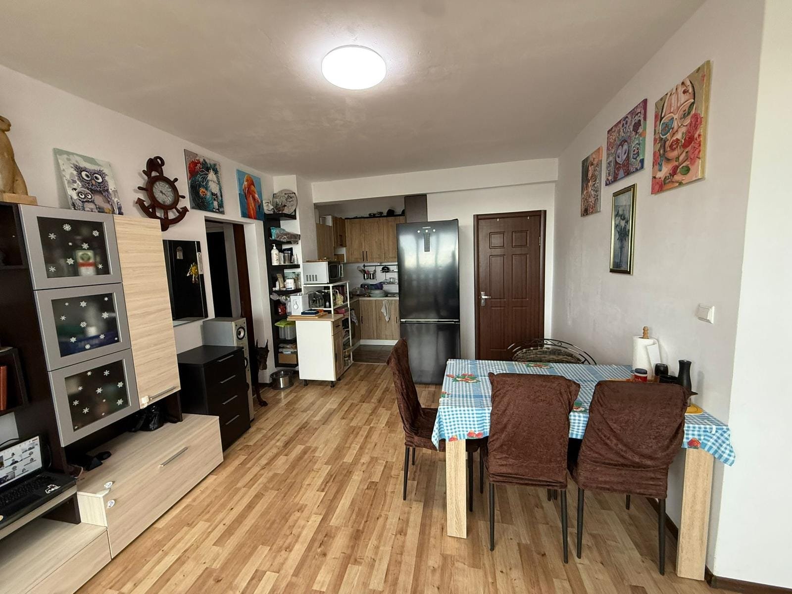 Современный интерьер квартиры с кухней и столовой, мебелью и художественными картинами, популярный вариант для покупки в Болгарии.