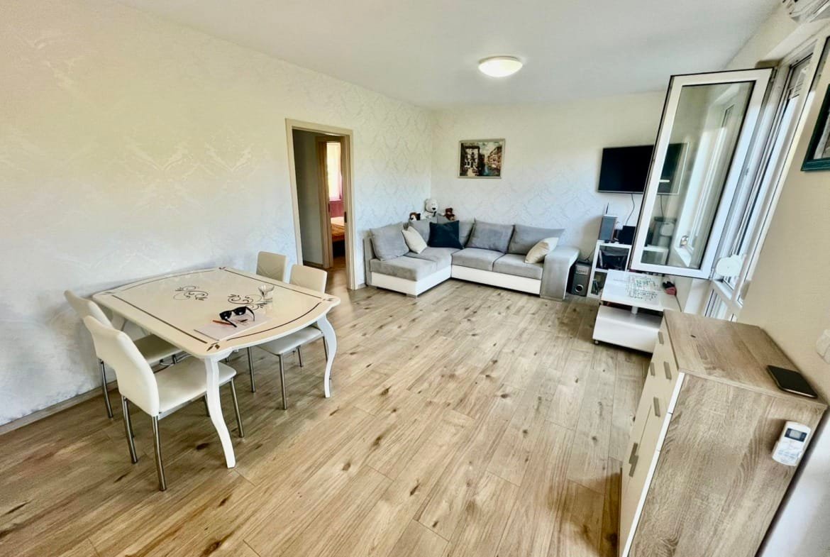 Современная гостиная в Болгарии с уютной мебелью, деревянным полом и телевизором, идеально подходящая для жизни или аренды.